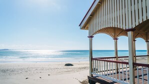Blick auf einen Strand mit einer hölzernen Laube.