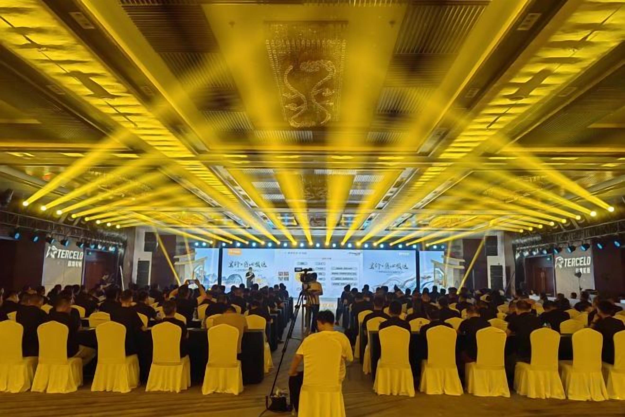 A large indoor venue with rows of chairs and a stage at the front.