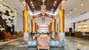 A spacious lobby with a marble floor, a central seating area, and a reception desk. - Bei Long Garden Hotel (Qingzhou)
