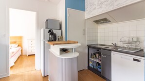 A compact kitchen with a built-in dishwasher, a coffee maker, and a microwave.
