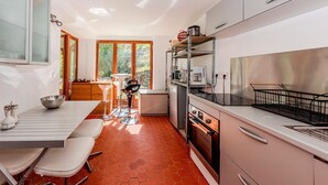 Una cocina moderna con comedor, un refrigerador pequeño y una estufa.