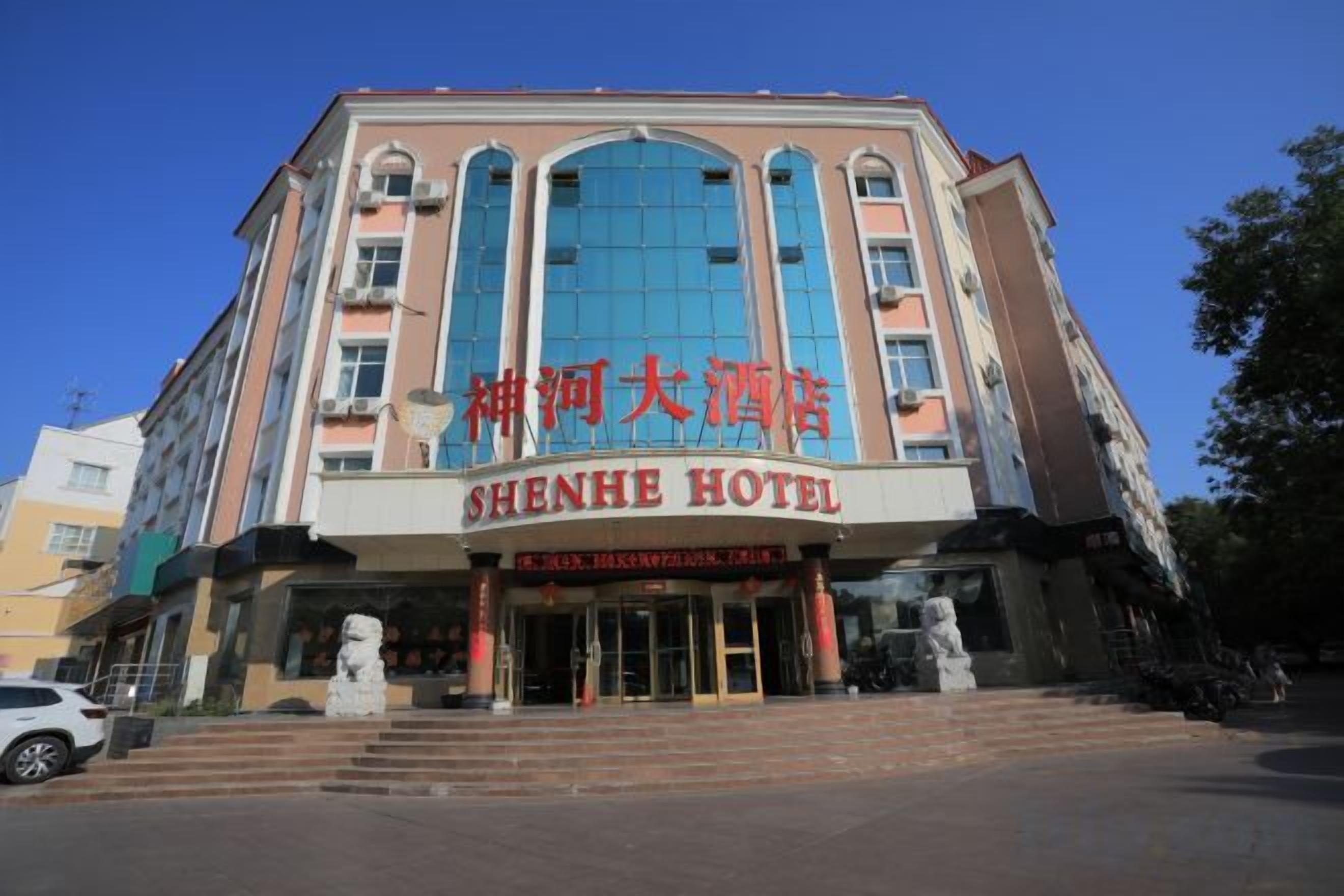 A hotel with a large entrance, multiple floors, and a prominent sign.