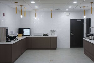 Una cocina moderna con una televisión de pantalla plana, una cafetera y un tostador sobre la encimera.