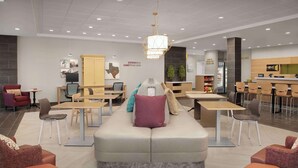 A modern lounge area with seating arrangements, a reception desk, and a food counter. - Home2 Suites By Hilton Georgetown Austin North (Georgetown)