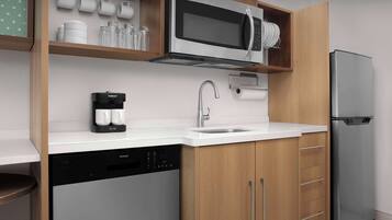 Uma cozinha moderna equipada com lava-louças embutida, máquina de café, micro-ondas e frigorífico.