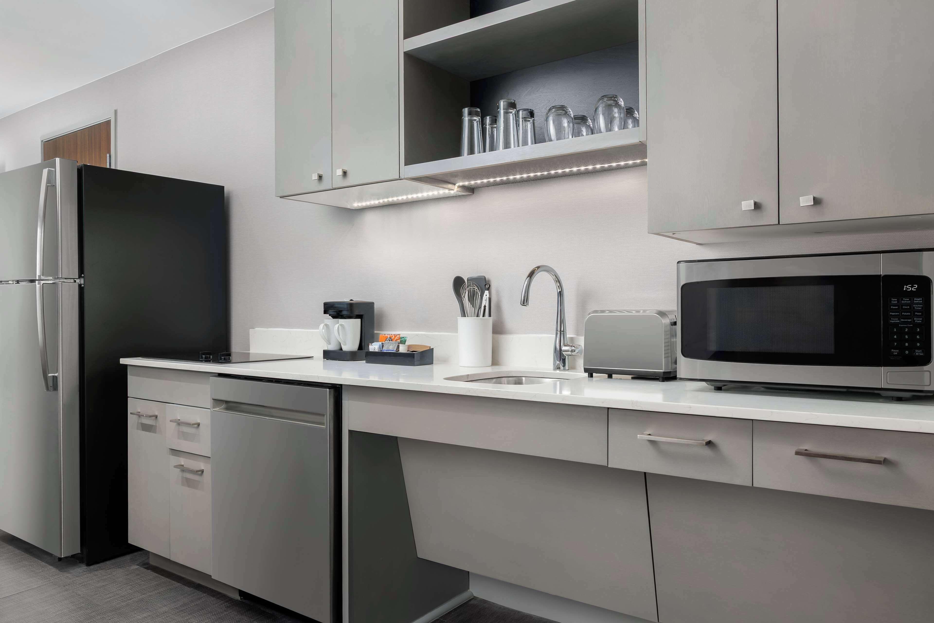 A modern kitchen with a stainless steel refrigerator, a microwave, and a dishwasher.