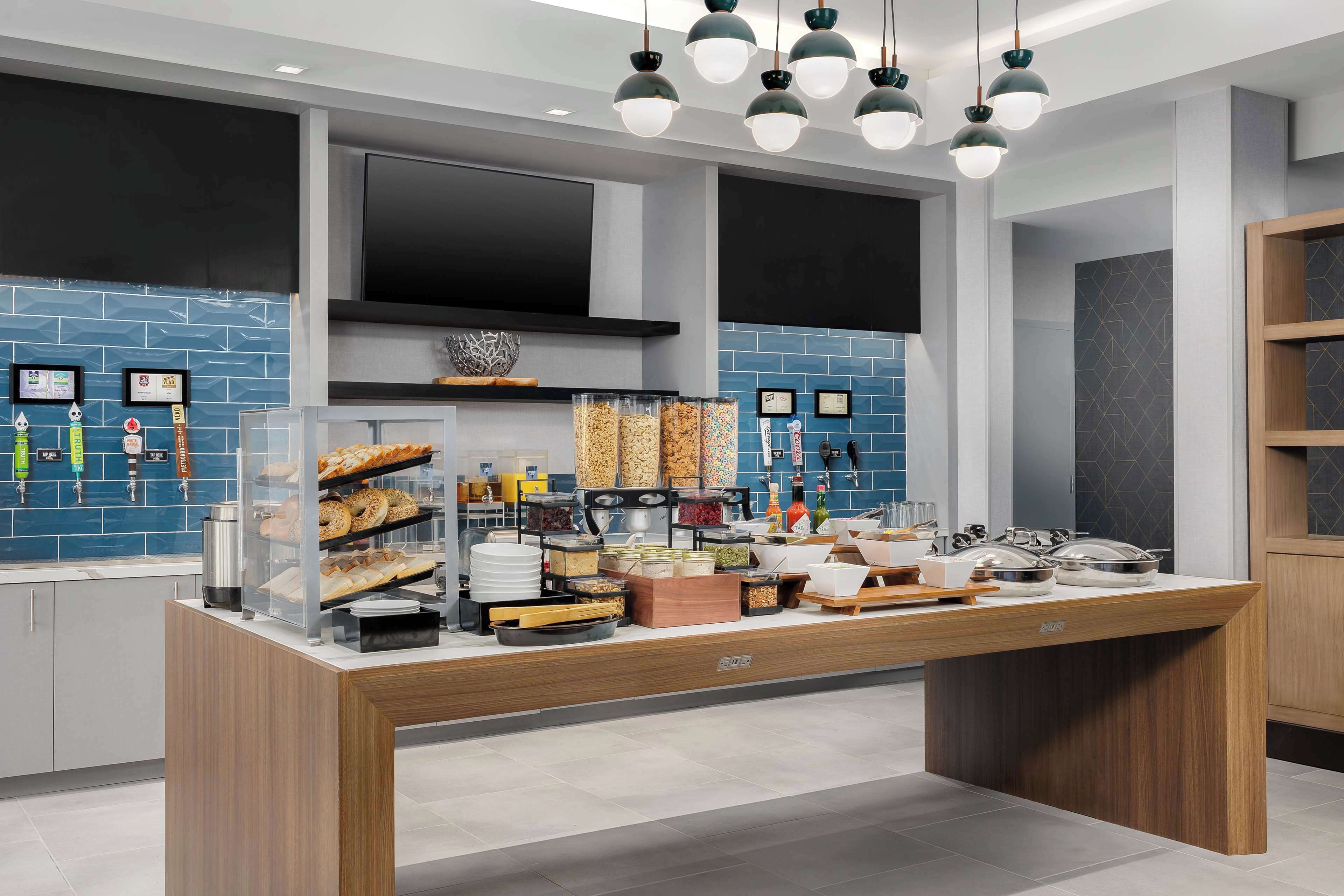 Uma cozinha moderna com ilha central, eletrodomésticos embutidos e painel de azulejos azuis.