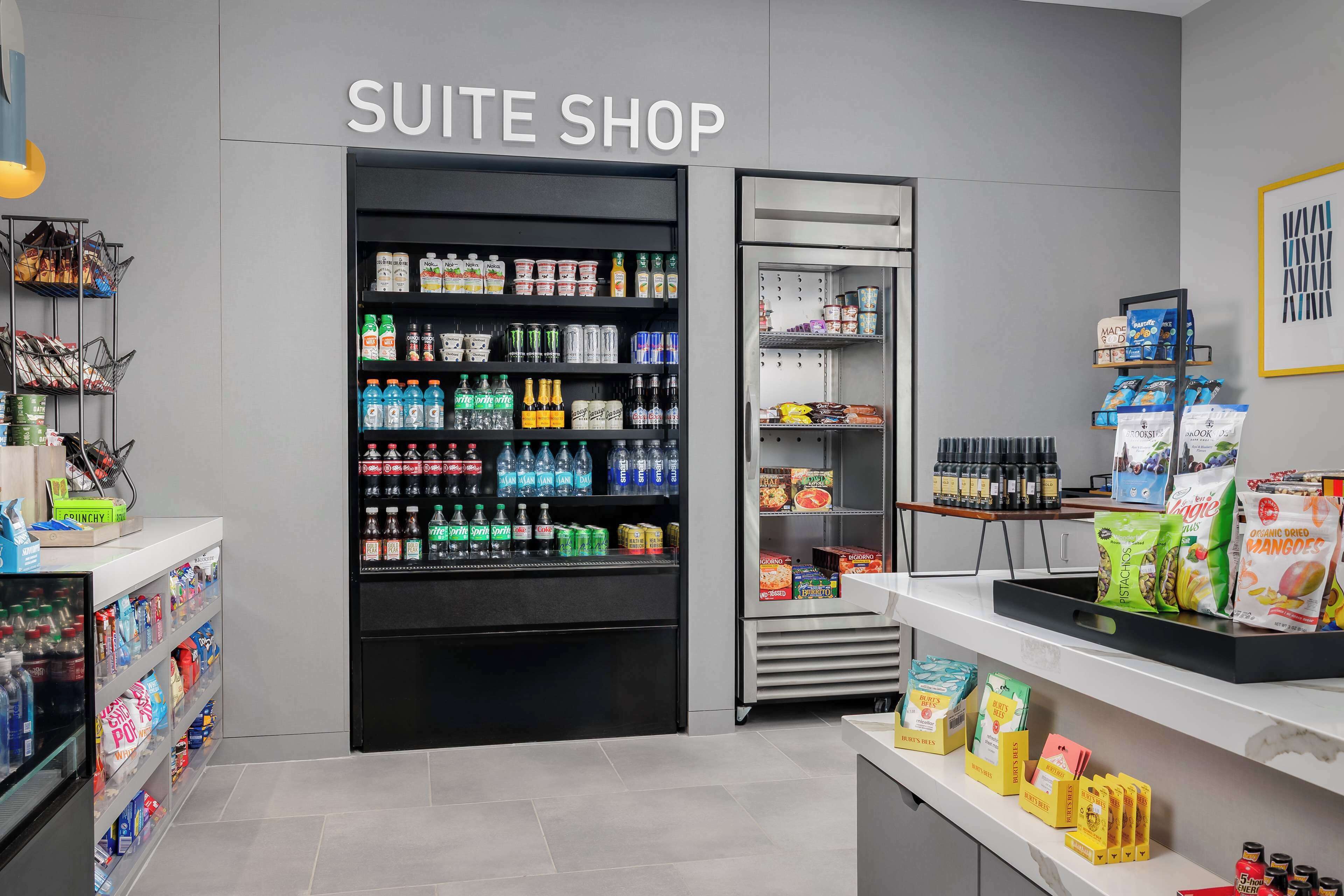 A suite shop with shelves stocked with beverages, snacks, and packaged goods.