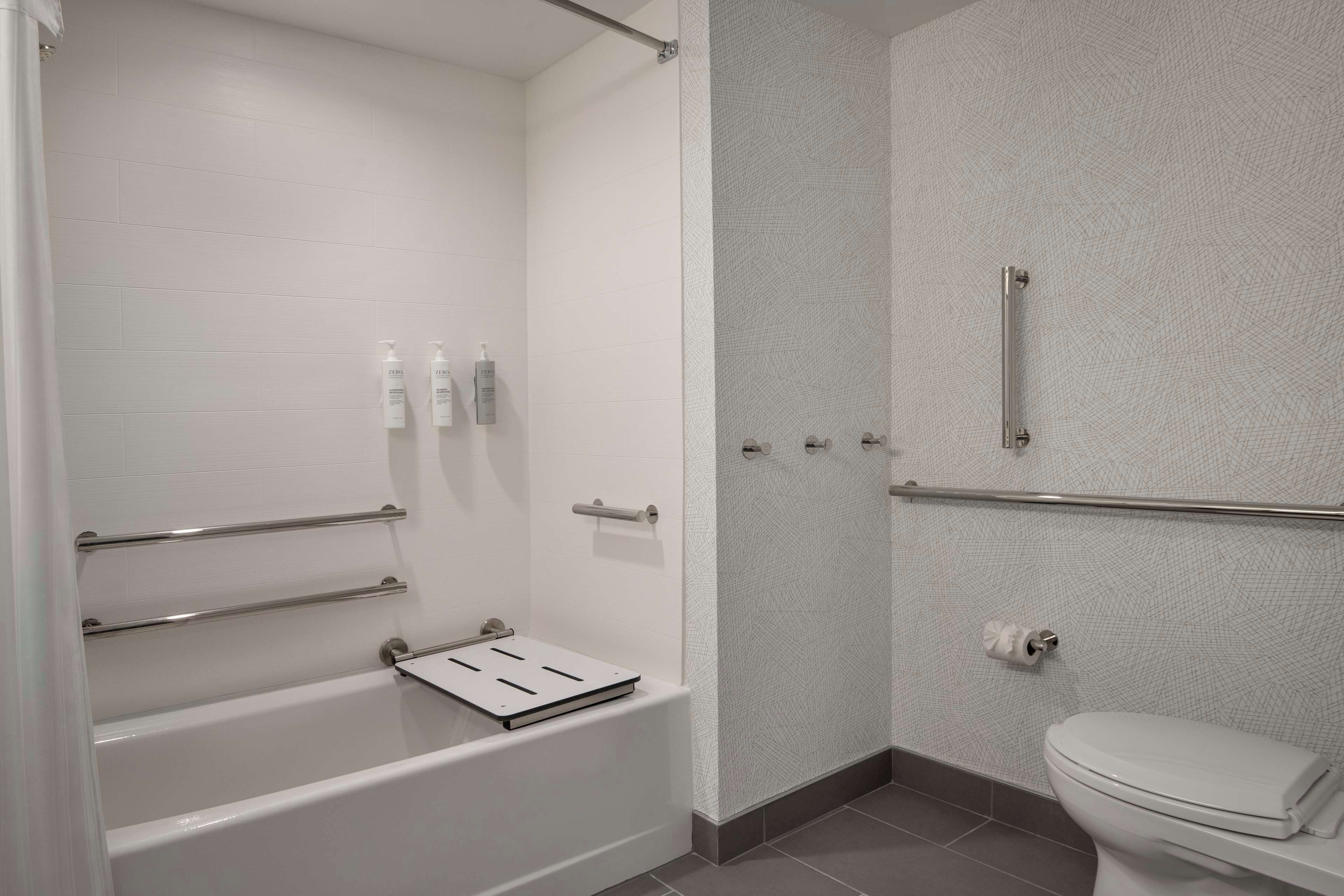 Une salle de bain moderne équipée d’une baignoire, d’une douche et de toilettes.