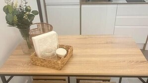 Una mesa de comedor con una cesta trenzada que contiene una vela y un objeto decorativo.