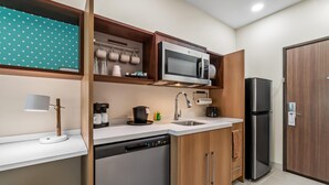 Una cocina compacta con microondas, cafetera y lavavajillas.