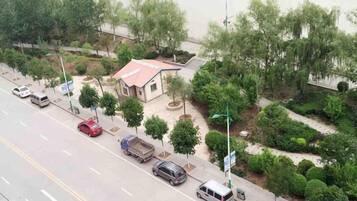 A road with parked cars and a building with a red roof.