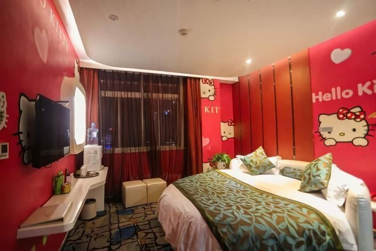 Ein Zimmer mit Bett, Schreibtisch, Spiegel, Fernseher und einem Fenster mit VorhÀngen.
