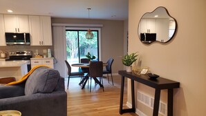 A modern kitchen with white cabinets, a microwave, and a dining area with a table and chairs. - Cozy 3 BR in center of town w/work space. Walking distance to main attractions  (Peachtree City)