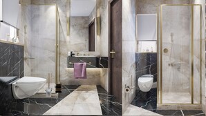 Ein modernes Badezimmer mit Marmorboden, Toilette in Weiß, Duschkabine und Waschtisch mit Spiegel.