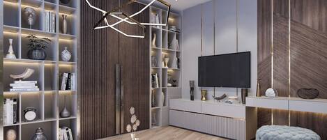 Uma sala de estar moderna com uma grande TV de tela plana, uma mesa de centro de vidro e um banquinho azul. Há estantes repletas de objetos decorativos e uma parede de destaque em madeira.