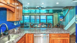 A kitchen with granite countertops, wooden cabinets, a stainless steel sink, and a dishwasher.