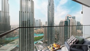 Un appartement situé dans un immeuble de grande hauteur, doté d’un balcon et offrant une vue sur la ville.