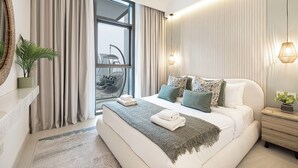 Une chambre moderne avec un grand lit, une vue sur la ville par la fenêtre et un balcon.