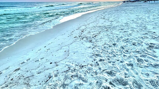 A beach with a clear sky and a sunset.