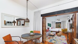 Habitación de hotel con comedor, cama, sofá y vista al salón.