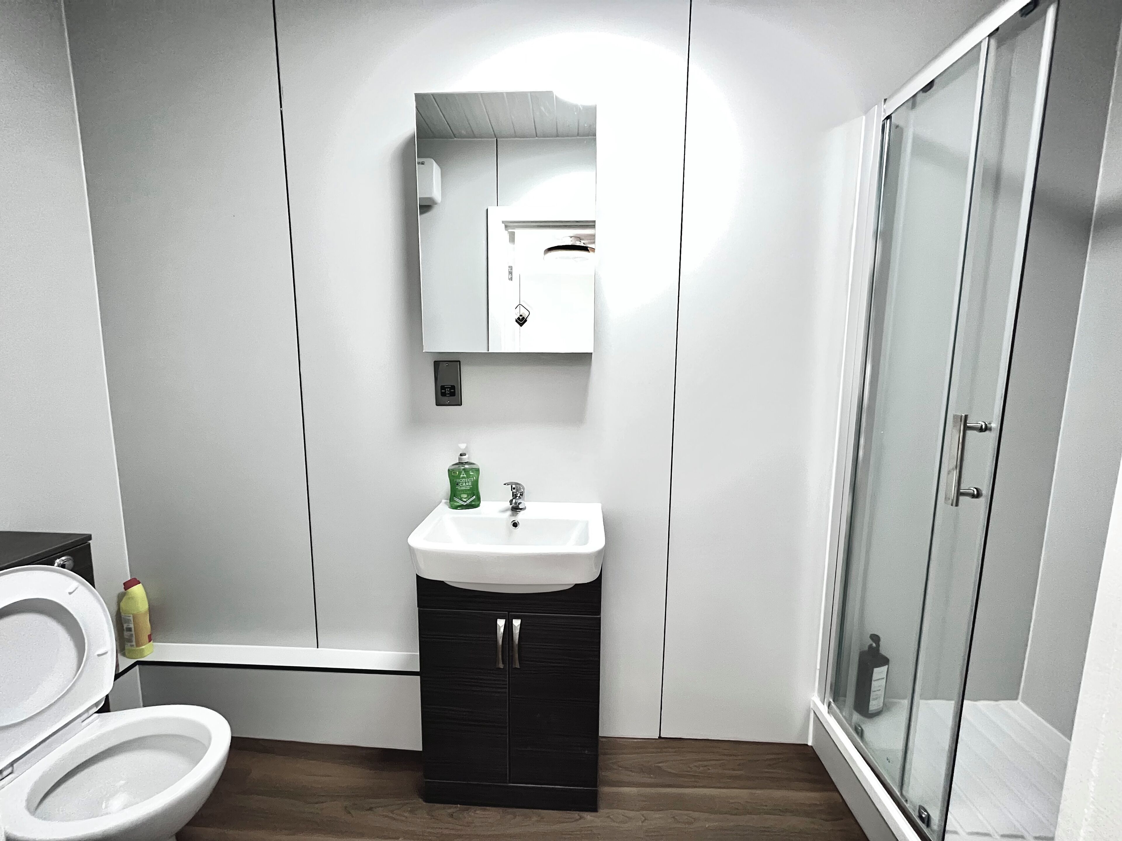 A modern bathroom with a toilet, sink, and shower.