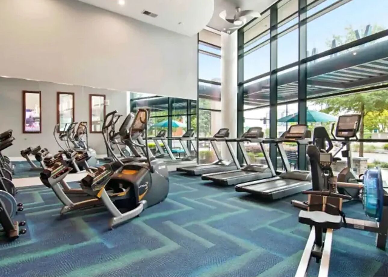 A gym with treadmills, stationary bikes, and elliptical machines.