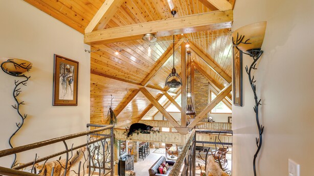 Ein großzügiger Raum im Loft-Stil mit hohen Decken, freiliegenden Holzbalken und einer gemütlichen Sitzecke.