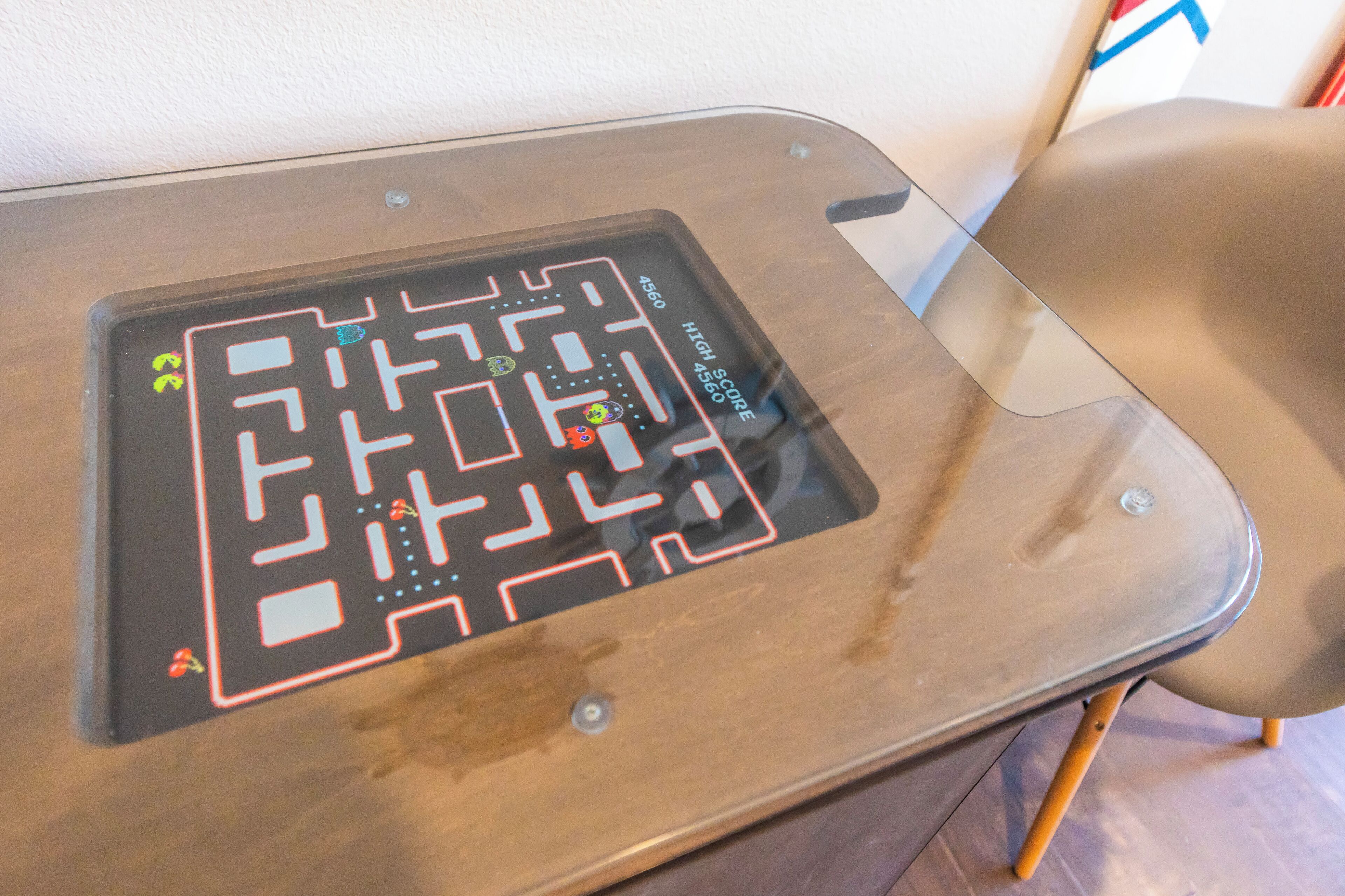 Una mesa con una interfaz de mapa digital, un panel de puntuación alta y un objeto pequeño a la izquierda.