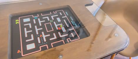 Una mesa con una interfaz de mapa digital, un panel de puntuación alta y un objeto pequeño a la izquierda.