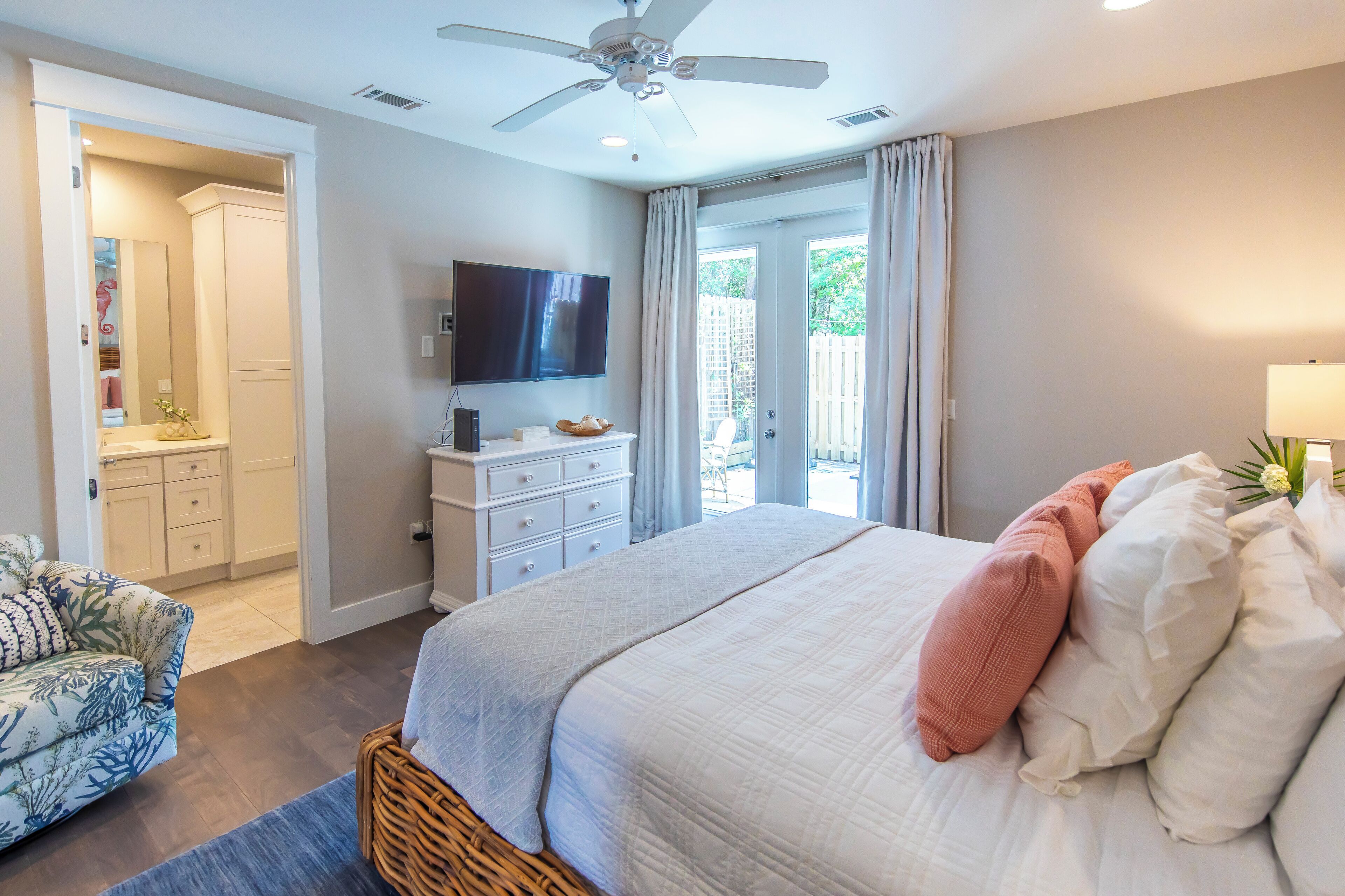 A bedroom with a bed, a TV, a dresser, and a chair.