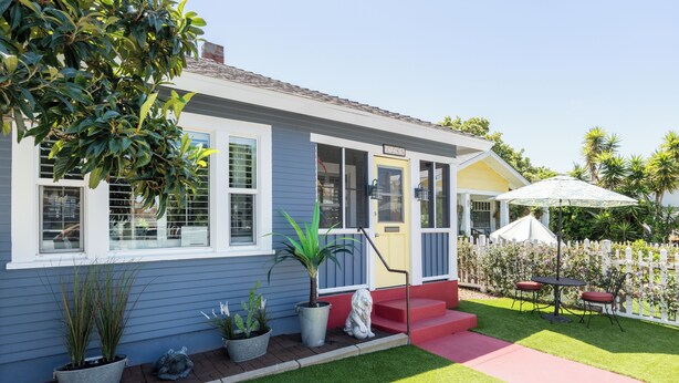 A house with a front porch, a potted plant, and a small statue.