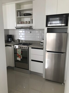 Enjoy cooking in this fully equipped kitchen with a gas stove, microwave, and refrigerator.
