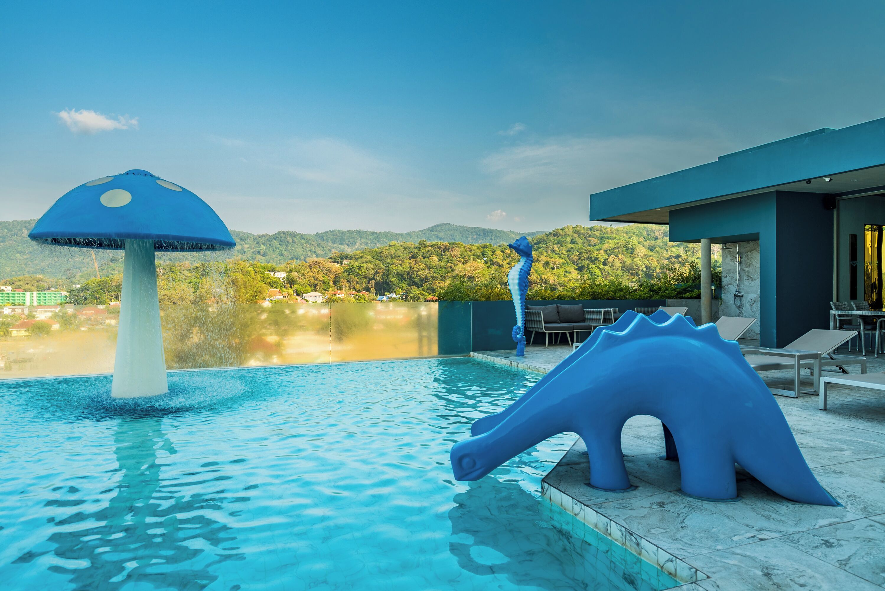 A swimming pool with a blue mushroom-shaped fountain and a blue dinosaur sculpture.