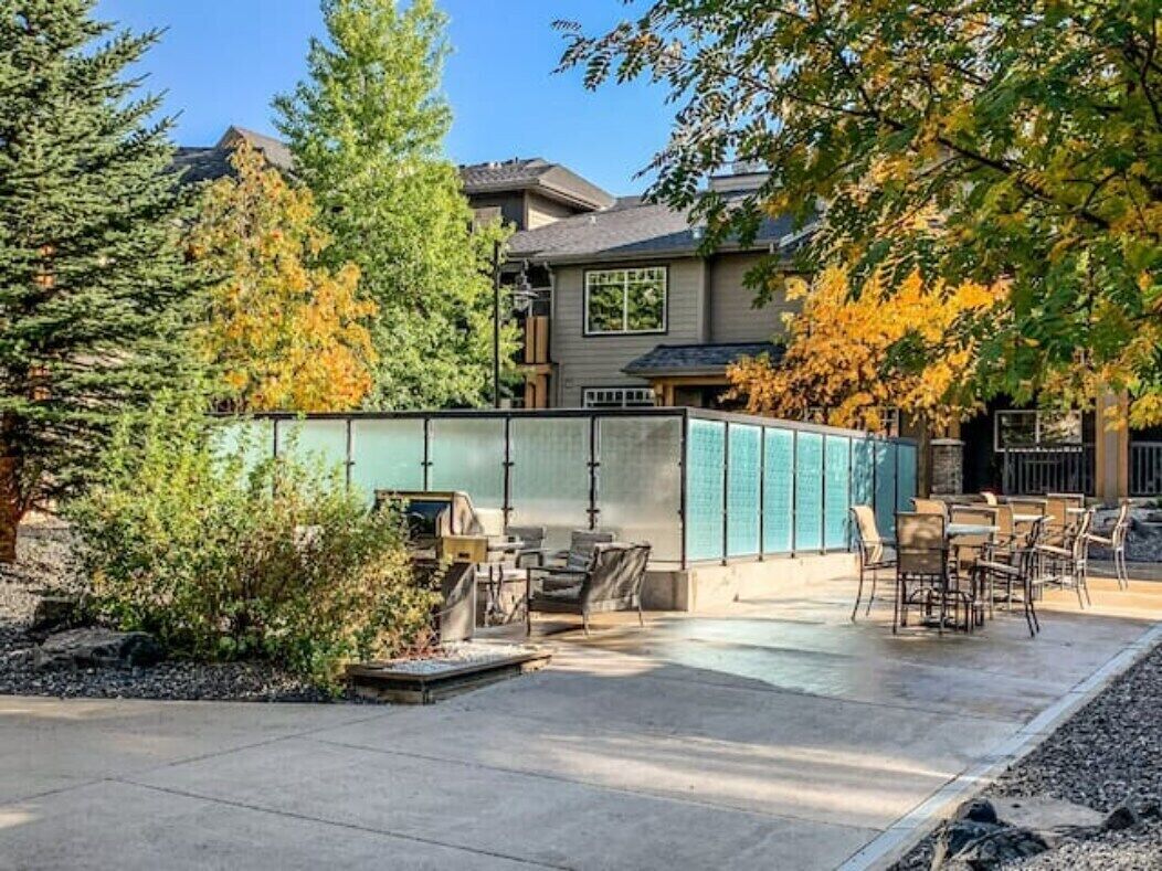 An outdoor patio area with a seating arrangement and a large window wall.