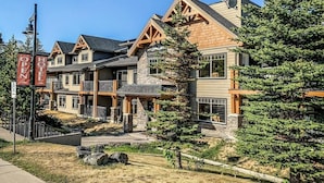 A multi-story hotel with a stone facade, wooden accents, and a prominent entrance.
