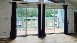 Ein geräumiges Zimmer mit einer großen Schiebeglasdoor zum Balkon.