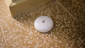 A white object with a logo on a speckled floor.