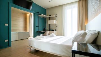 A modern hotel room with a bed, bedside table, and a built-in wardrobe.