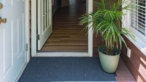 A wooden exterior with a welcome sign, a potted plant, and a door leading to a hallway. - Tre L at Watauga Lake - Butler, TN (Johnson County)