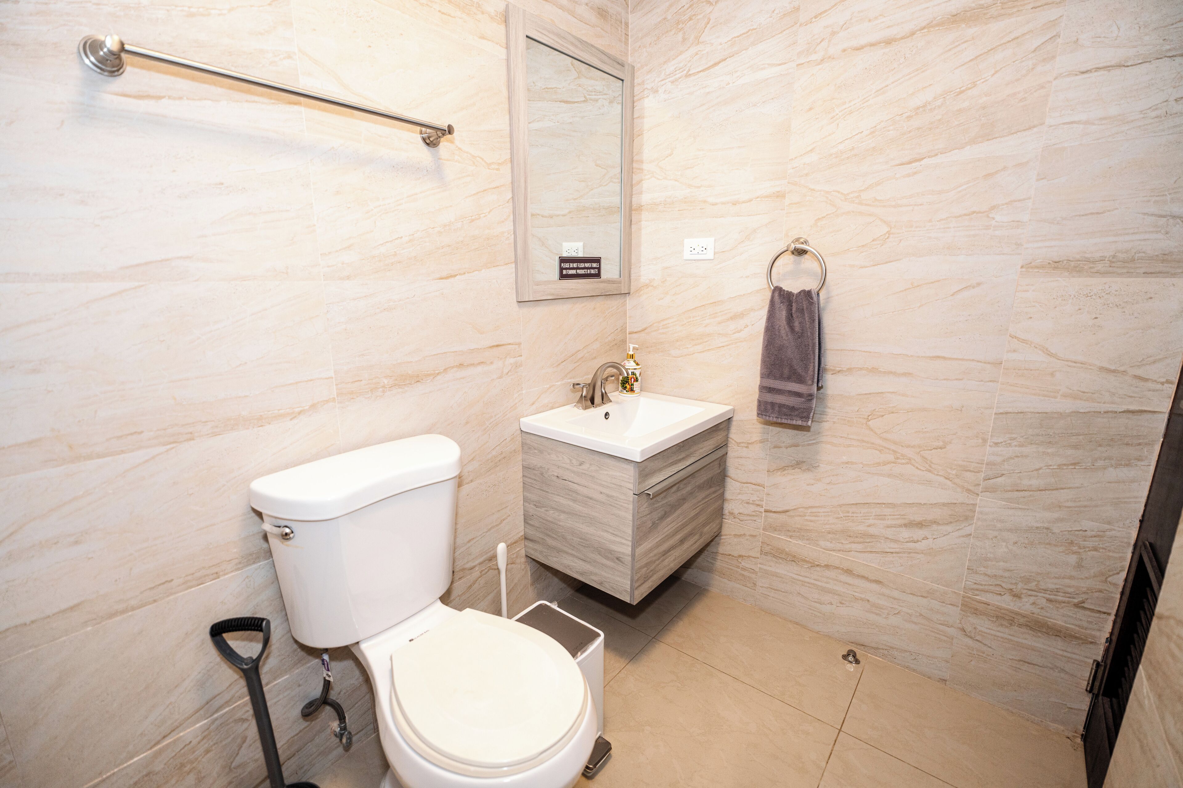 Un baño moderno con inodoro, lavamanos y espejo.