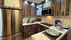 Eine moderne Küche mit Holzschränken, Edelstahlgeräten und einer weißen Arbeitsplatte.