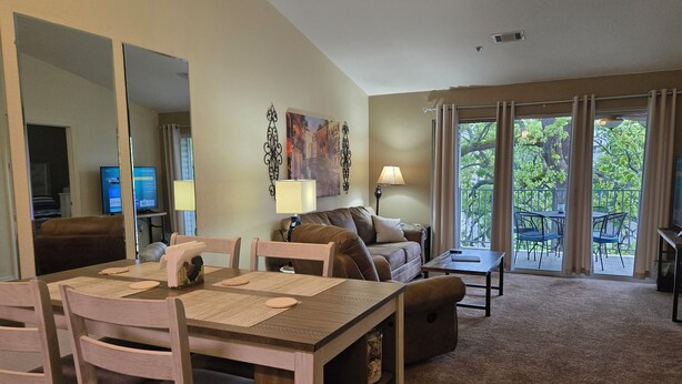 A living room with a dining area, a sofa, a coffee table, and a TV. - ROMANTIC SUMMER GETAWAY FOR TWO!! EASY WALK-IN 1BD 1BA CONDO... NO STEPS!!! (Branson)