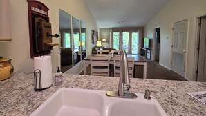 A kitchen with a sink, a ceiling fan, and a dining area with a table and chairs. - ROMANTIC SUMMER GETAWAY FOR TWO!! EASY WALK-IN 1BD 1BA CONDO... NO STEPS!!! (Branson)