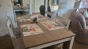 A dining table with placemats, chairs, and a decorative item on the table. - ROMANTIC SUMMER GETAWAY FOR TWO!! EASY WALK-IN 1BD 1BA CONDO... NO STEPS!!! (Branson)