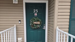 A teal front door with a 'welcome' sign, a 'no smoking' sign, and a mailbox on the wall. - ROMANTIC SUMMER GETAWAY FOR TWO!! EASY WALK-IN 1BD 1BA CONDO... NO STEPS!!! (Branson)