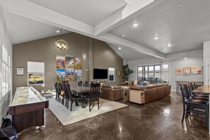 Relax in a spacious living area with a large dining table, comfortable seating, and a flat-screen TV.