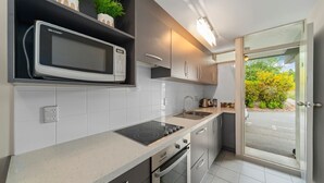 A modern kitchen with a built-in microwave, a stove, and a sink. There are cabinets and a countertop. - 300 Lake Terrace (Taupo)