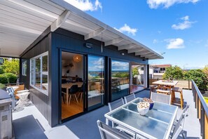 A modern house with a covered patio, large glass doors, and outdoor furniture. - Lakeview Lookout Taupo (Taupo)