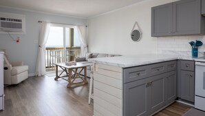 Eine moderne Küche mit grauen Schränken, einer Marmorarbeitsplatte und einem eingebauten Backofen.